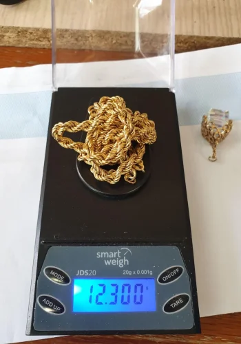 An 18ct gold necklace chain on a set of weighing scales